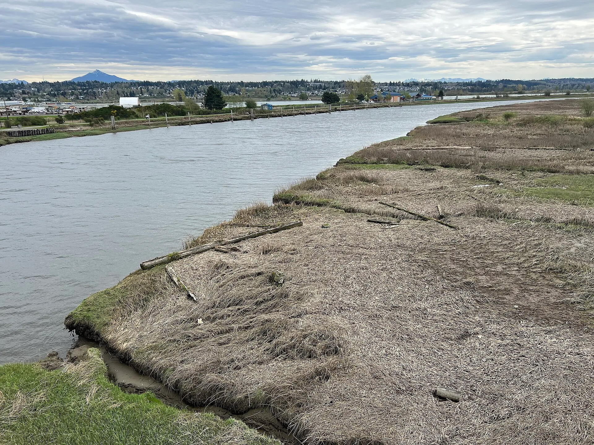 Ebey Slough at Marysville, a wide grey channel between flat marsh banks