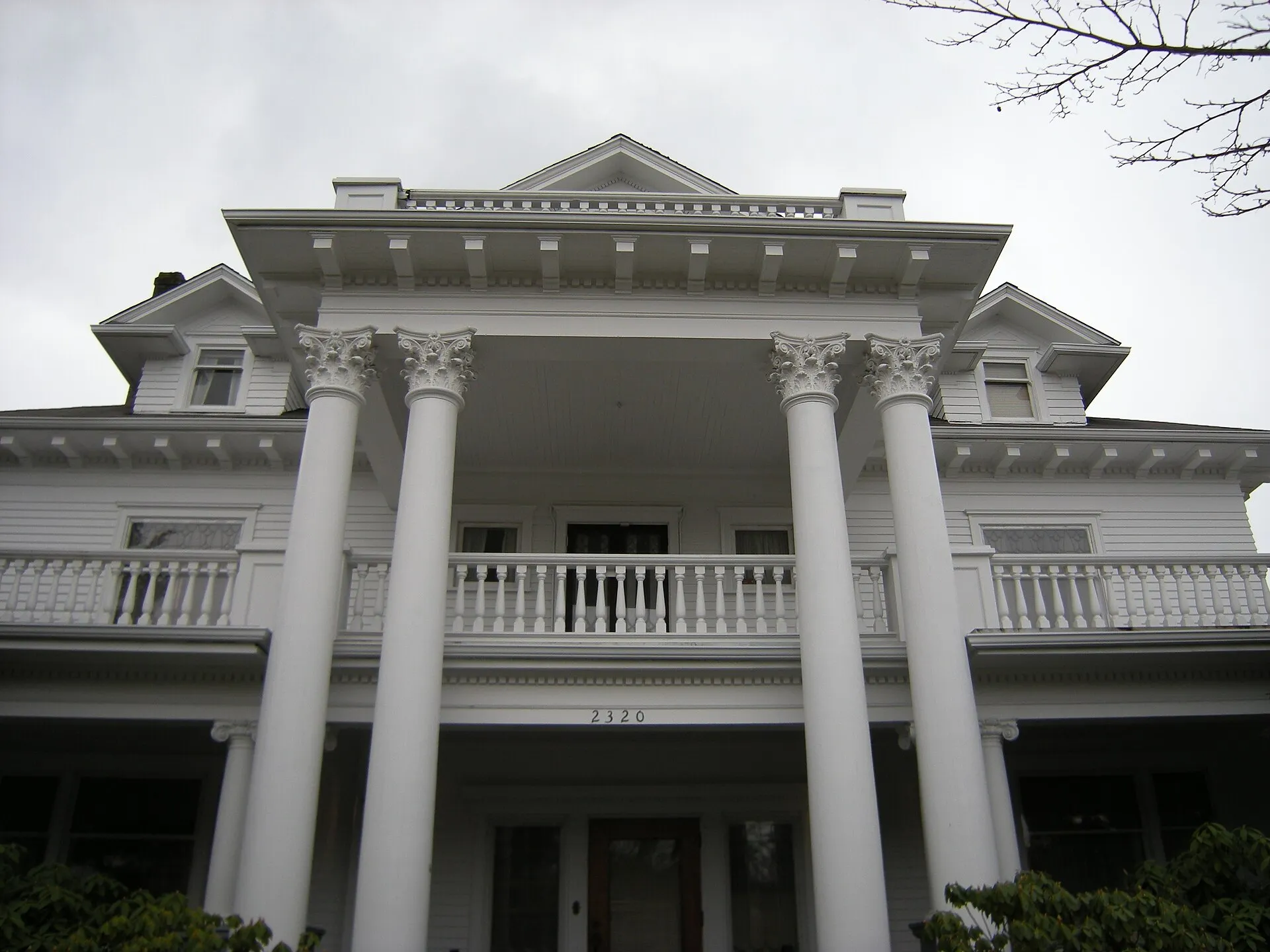 A white columned porch on Rucker Avenue under a grey sky